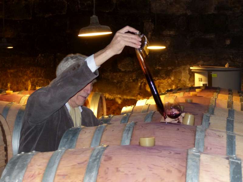 François carefully extracts a sample from one of his barrels.