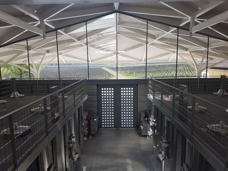 Chateau Margaux vats with vines in the background